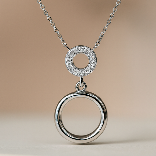 Silver necklace with two interlocking rings on a beige background