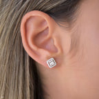 תקריב של אוזן אישה מעוטרת בעגילי סטוד ריבועיים