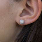 תקריב של אוזן של אדם שעונדת זוג עגילי סטוד עגולים.