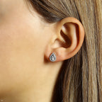 תקריב של אישה עונדת עגיל בצורת טיפה