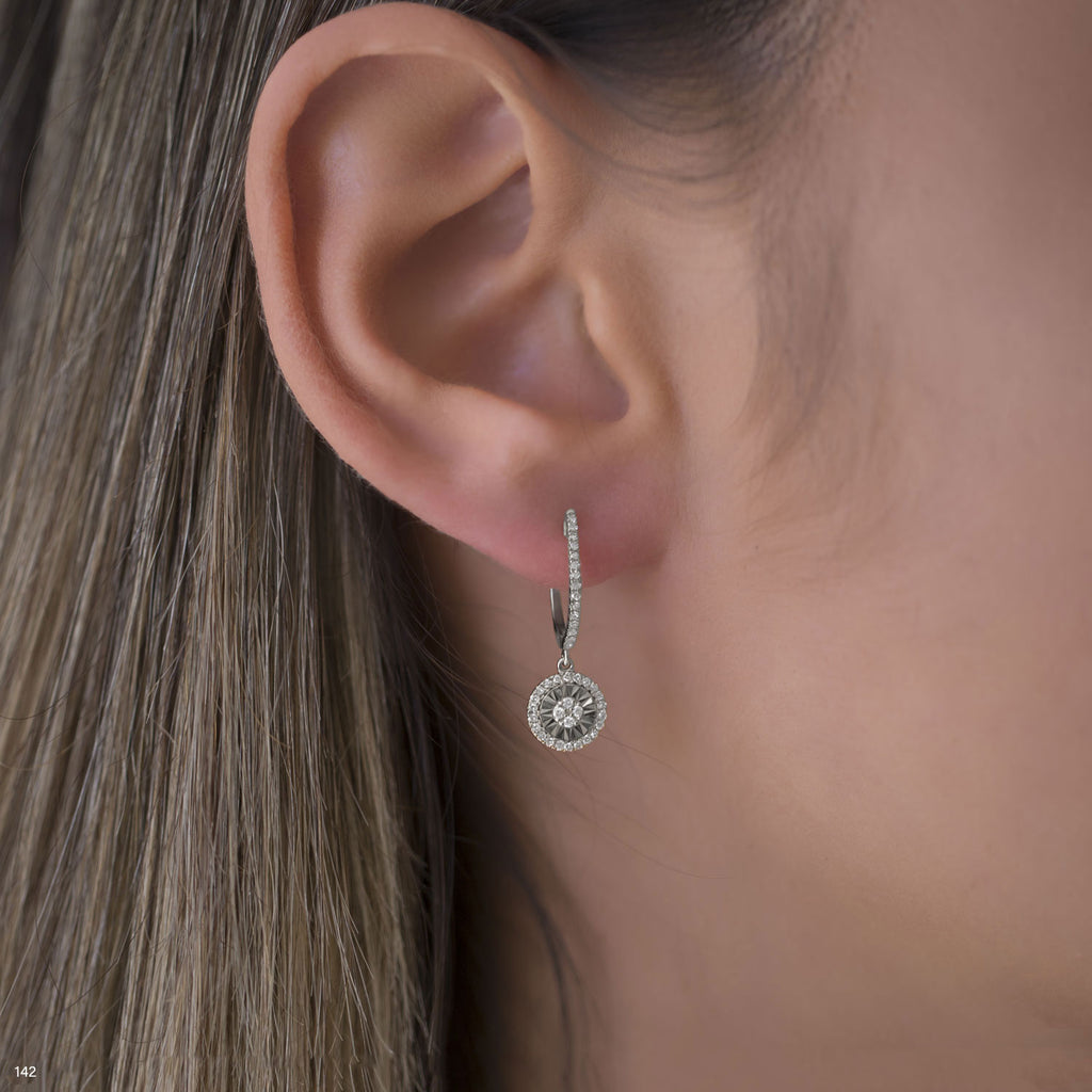 תקריב של אוזן אישה המציגה עגיל כסף מעוצב.