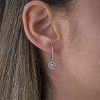 תקריב של אוזן אישה המציגה עגיל כסף מעוצב.