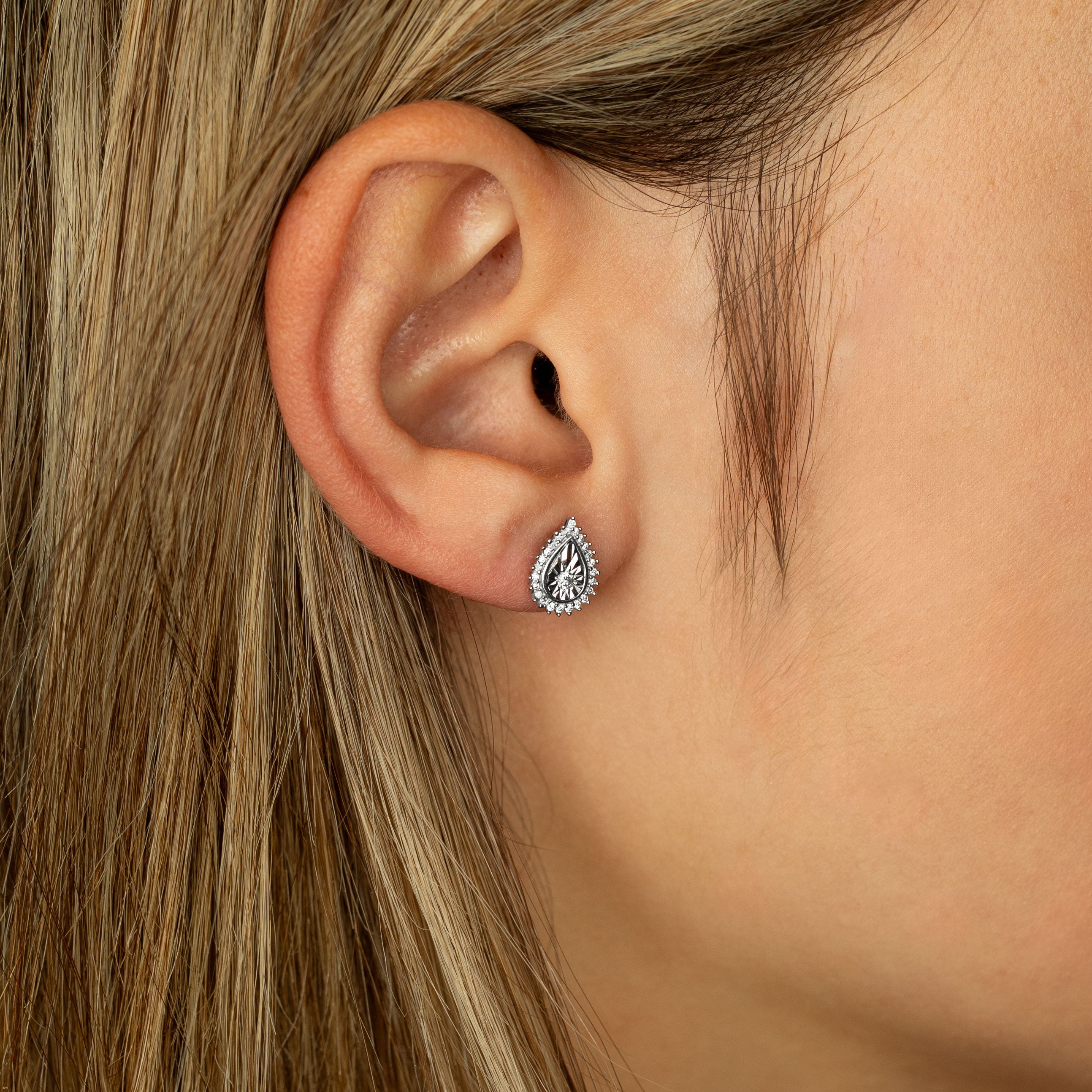 תקריב של אוזן אישה עם עגיל טיפה.