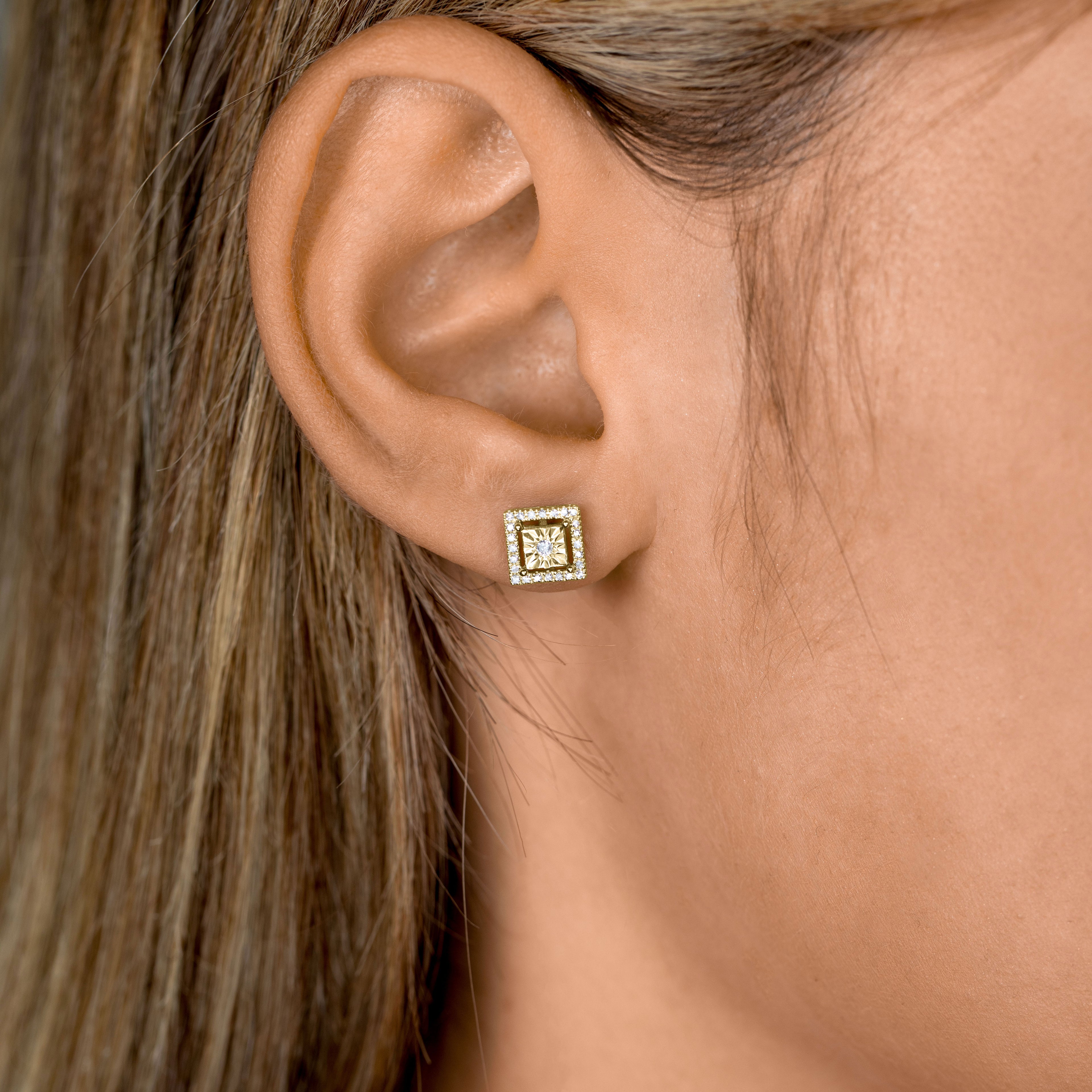 תקריב של אוזן של אישה שעונדת עגיל בצורת ריבוע.