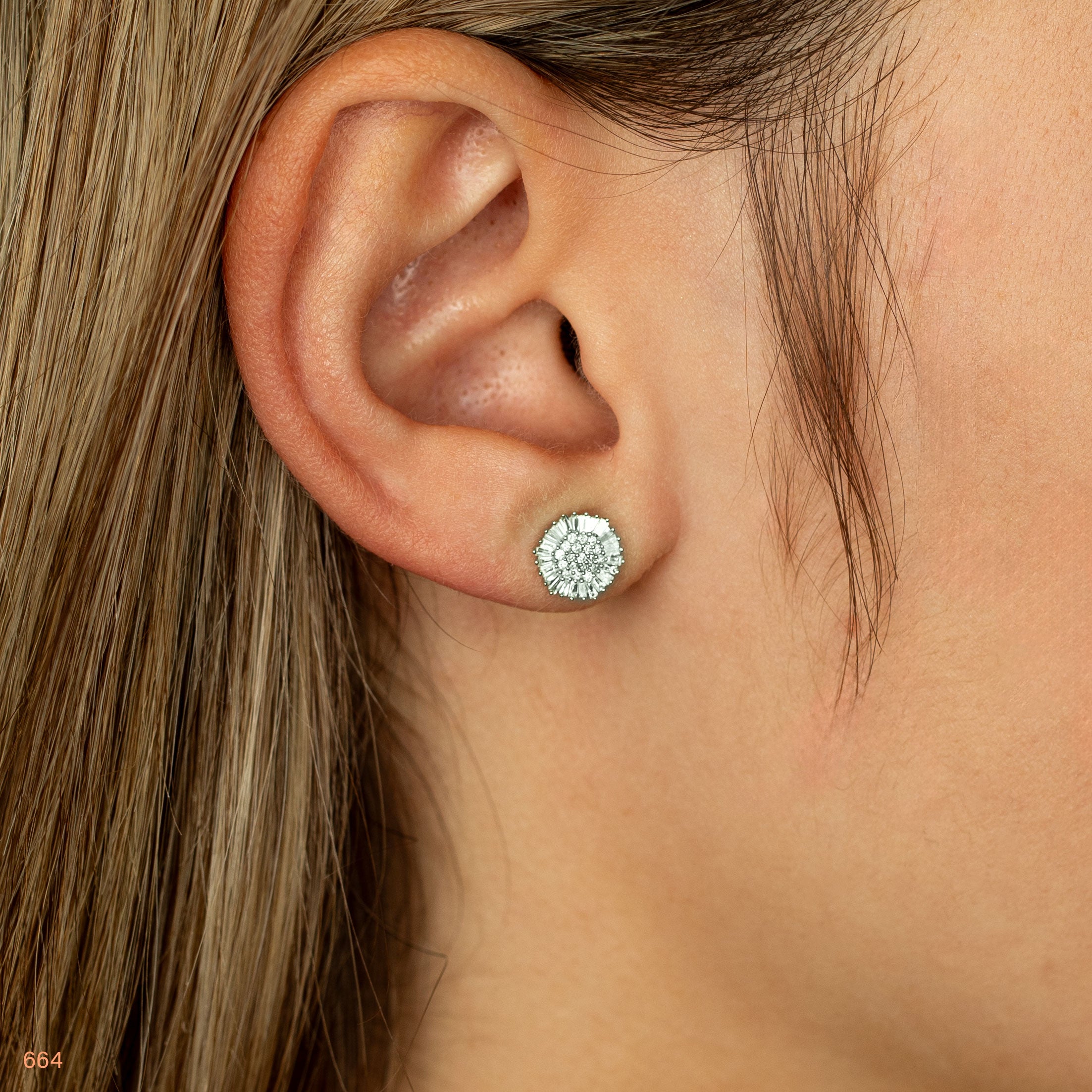 תקריב של אוזן אישה עם עגיל סטוד דקורטיבי.