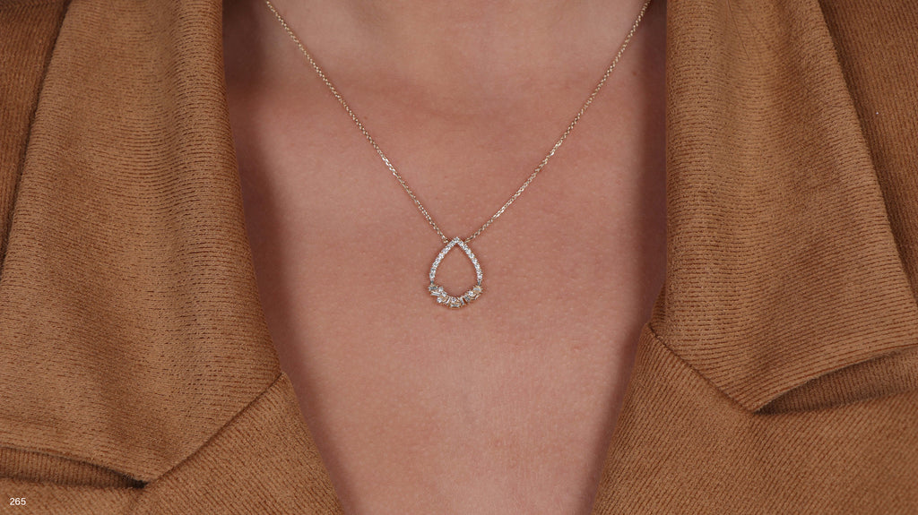 תקריב של אדם שעונד שרשרת טיפה כסף.