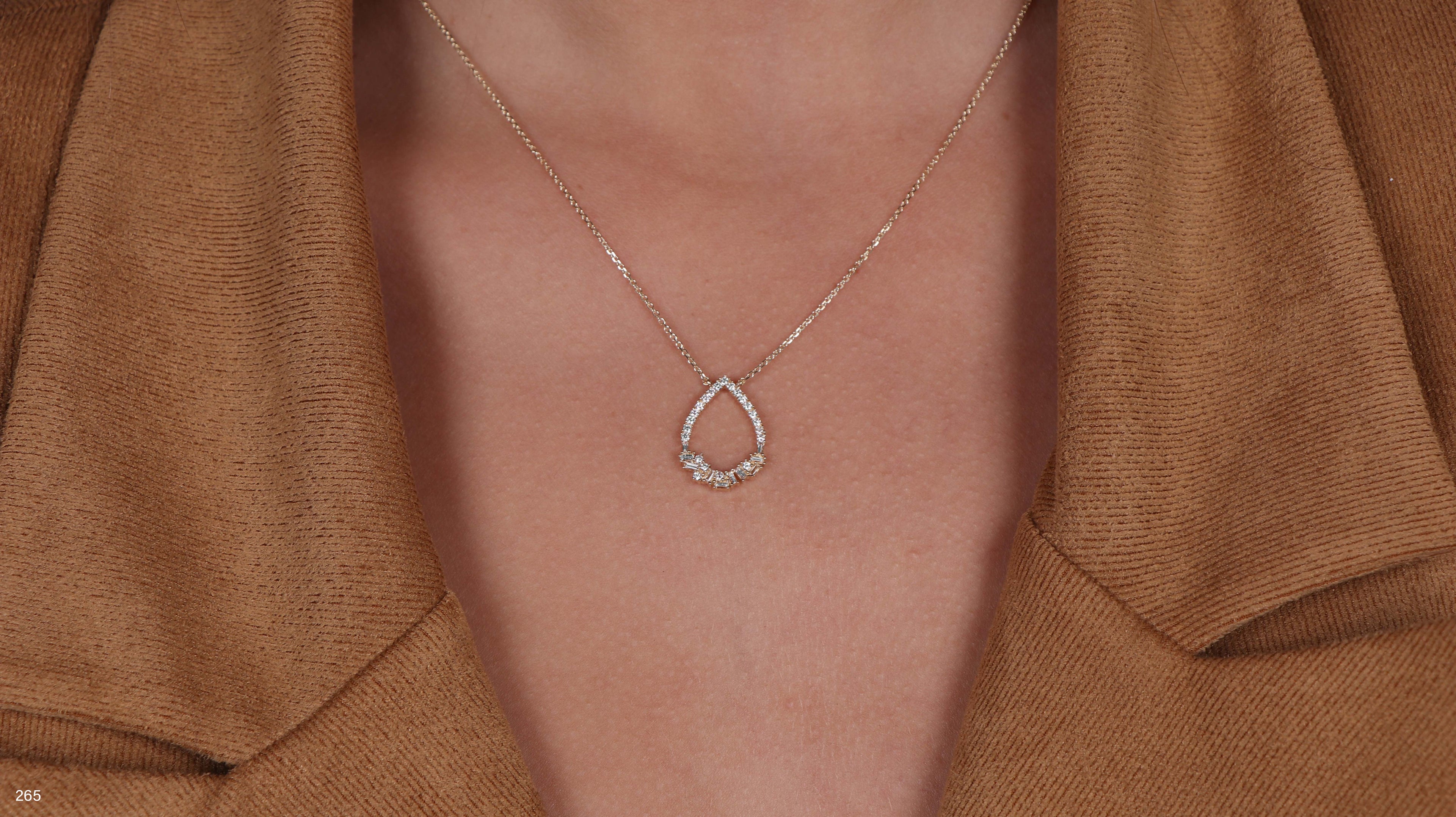 תקריב של אדם שעונד שרשרת טיפה כסף.