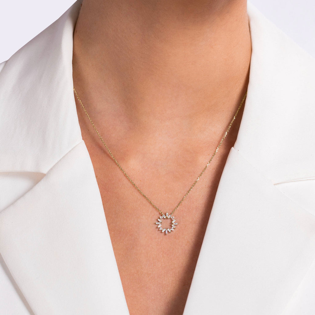 תקריב של שרשרת זהב עם תליוני קשת שמש שנלבשת על ידי אדם בחליפת לבן.