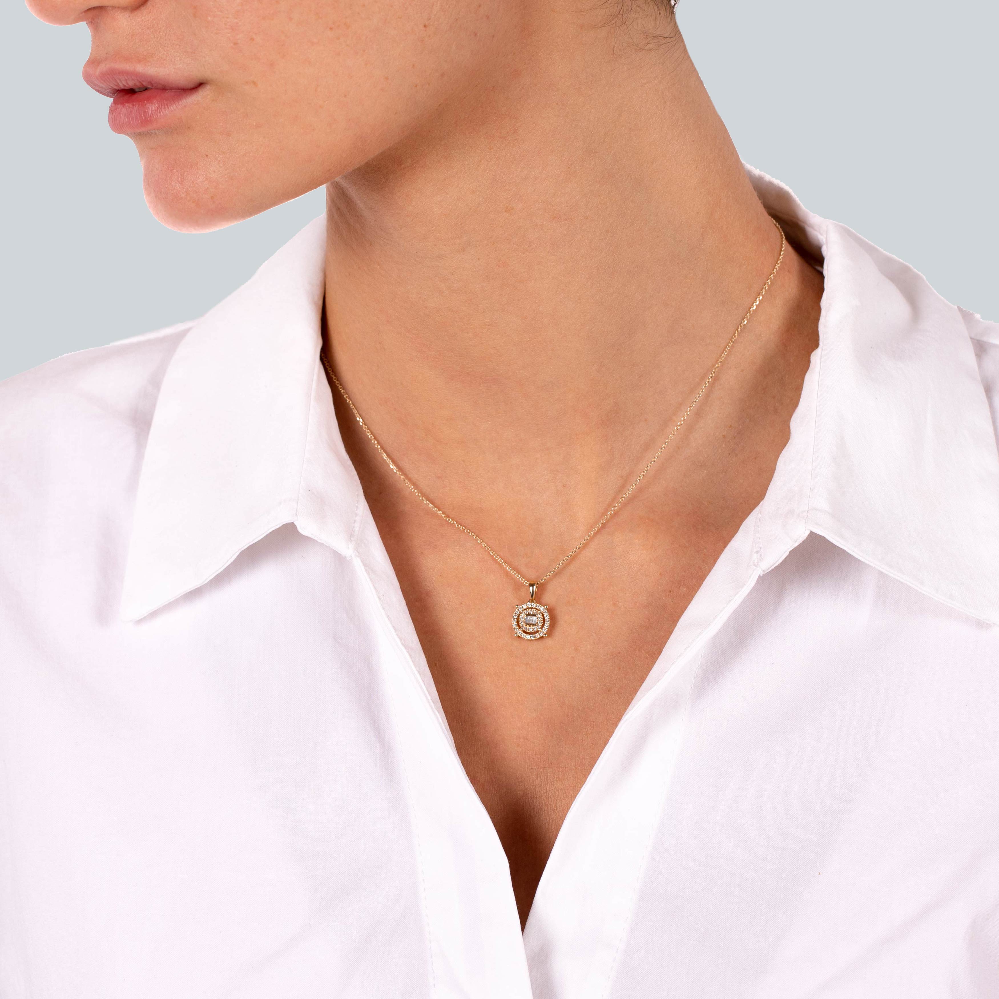 תקריב של צוואר אישה עם שרשרת תליון עדינה, לובשת חולצה עם צווארון לבן.