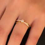 תקריב של טבעת זהב עם אבן מרכזית והדגשות דקורטיביות על יד.