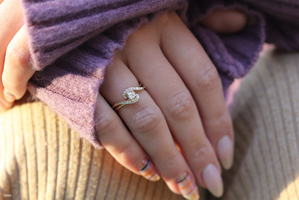 תקריב של יד עונדת טבעת עדינה, מונחת על משטח מרקם.