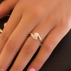 תקריב של יד לובשת טבעת גל זהב רוז עם פרטים מנצנצים.