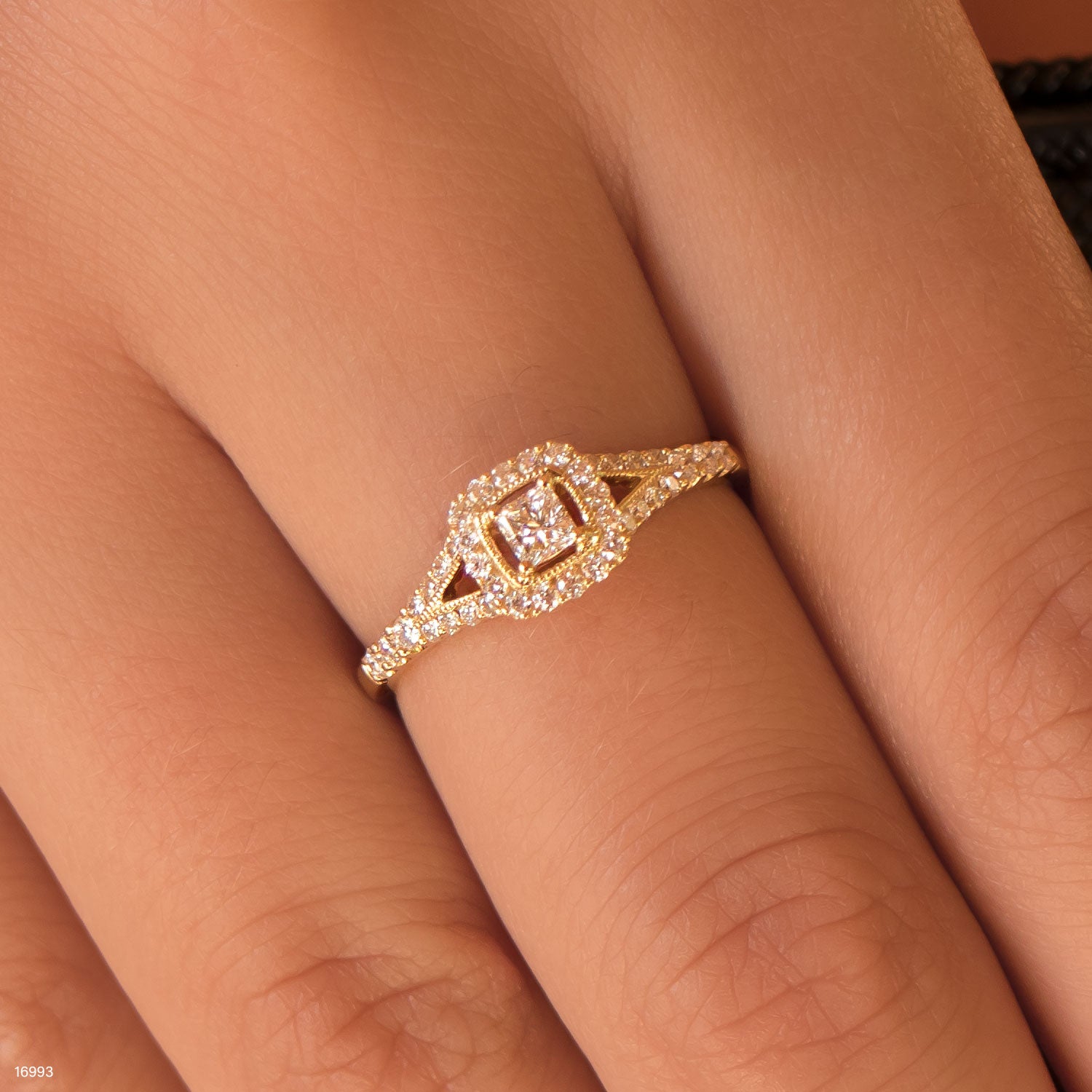 טבעת זהב עם הדגשות יהלום שנלבשת על אצבע.