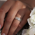 תקריב של יד עונדת שלושה טבעות מנצנצות עם רקע פרחוני.