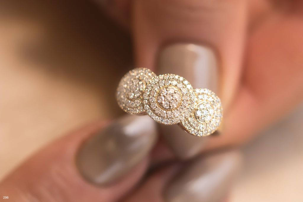 תקריב של טבעת זהב מבריק עם יהלומים בעיצוב מעגלי.