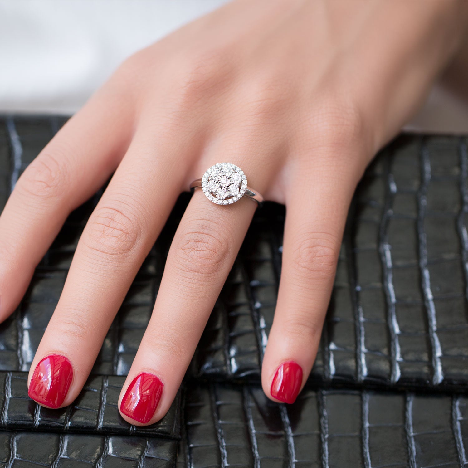 תקריב של יד המראה טבעת מבריקה על משטח מרקם.