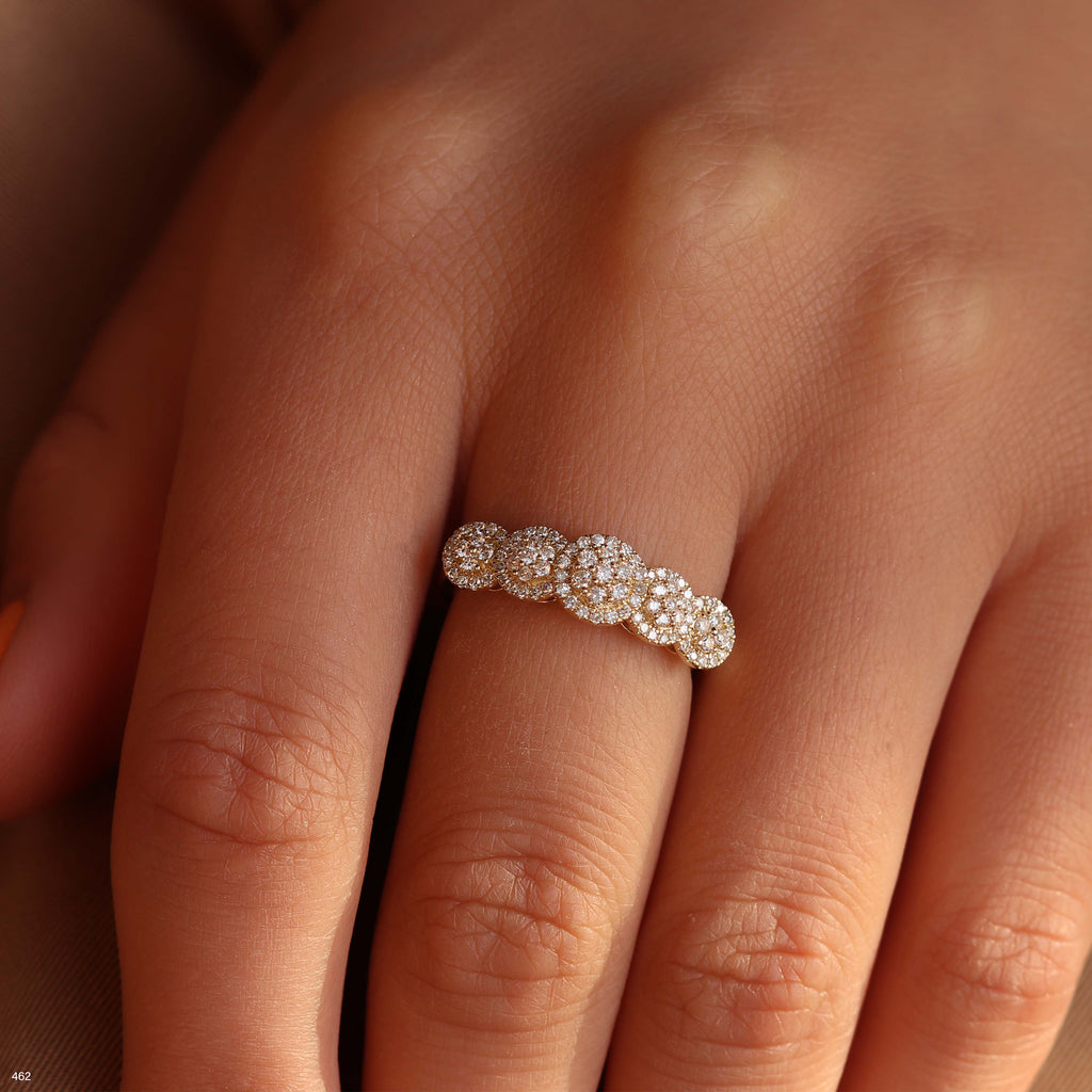 תקריב של יד עונדת טבעת מעוטרת עם קישוטים מעגליים.