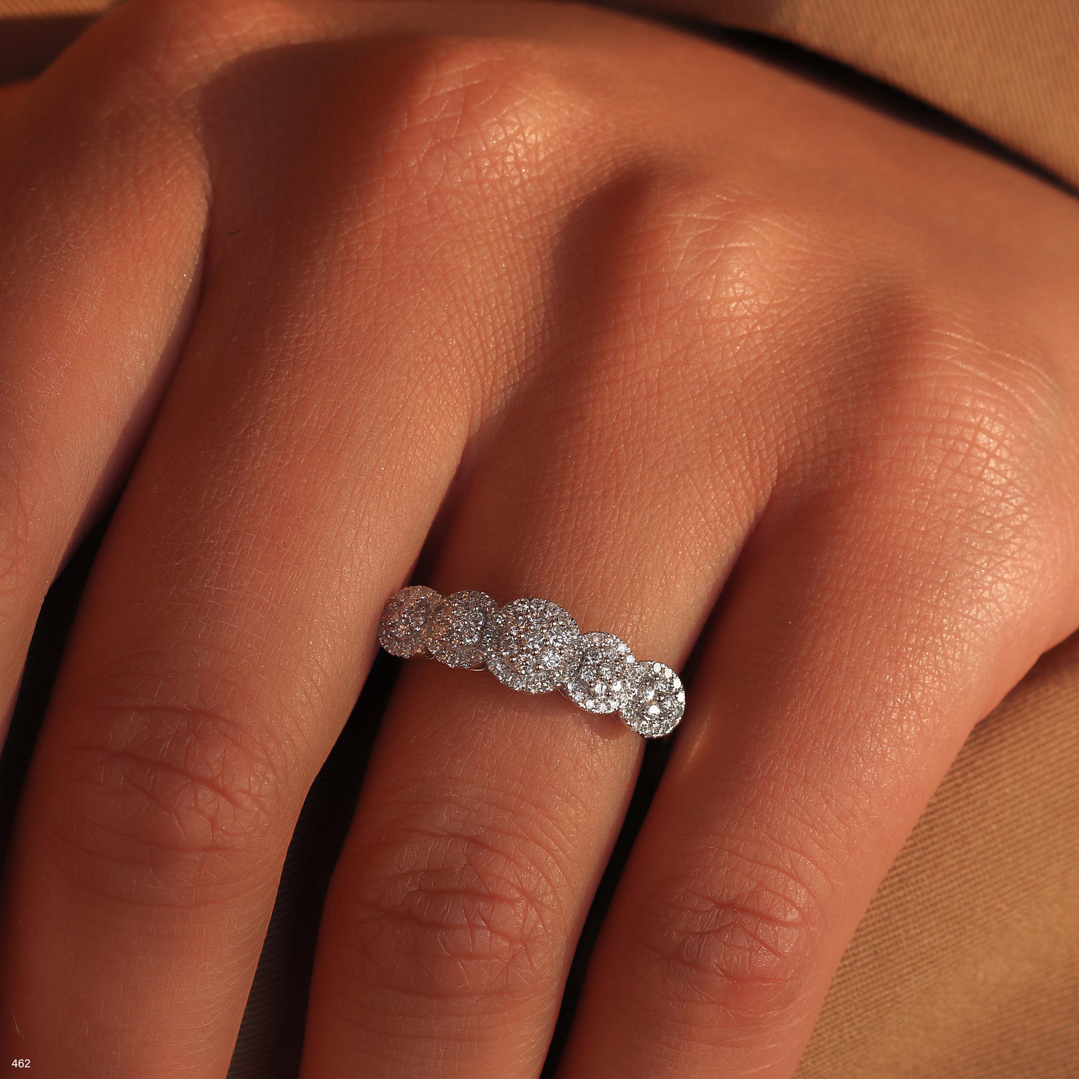 תקריב של יד שעונדת טבעת יהלום נוצצת.