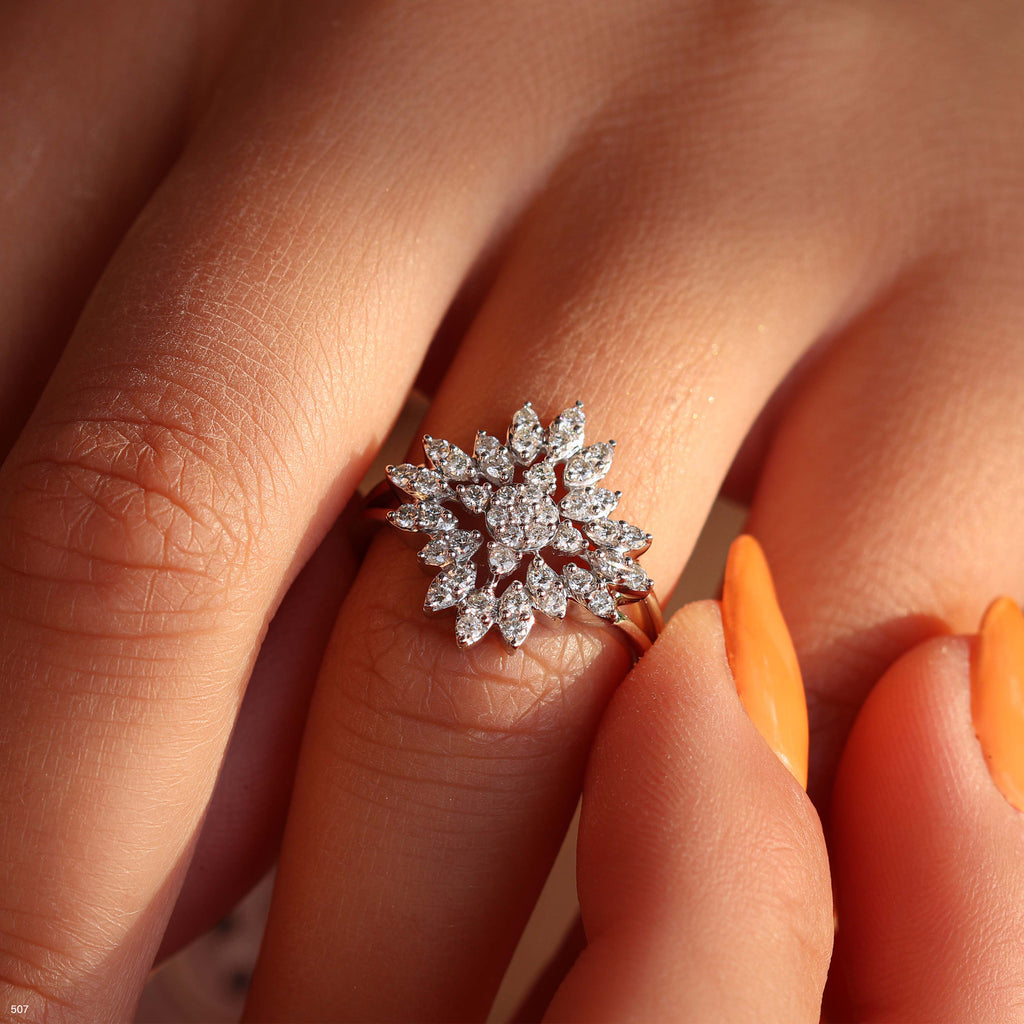 תקריב של טבעת פרחונית עם יהלומים על אצבע של אדם.