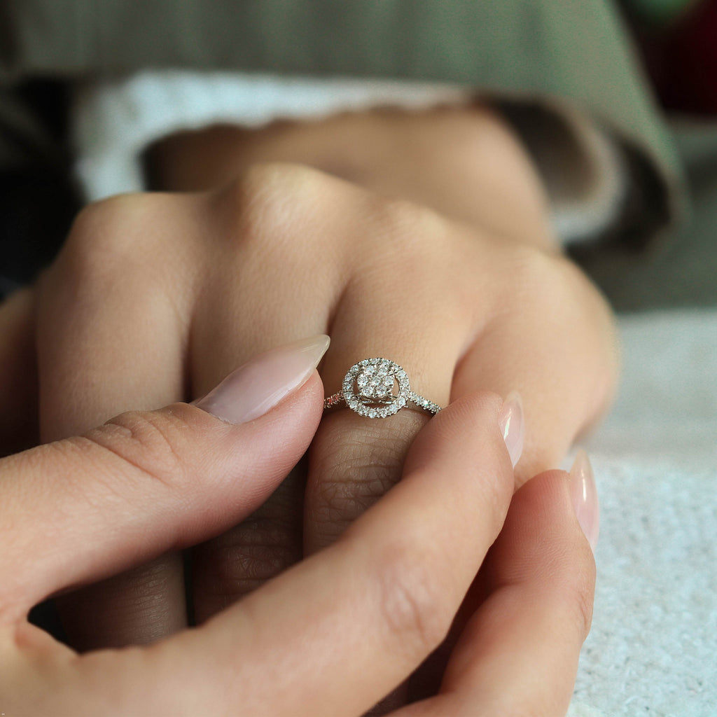 תקריב של יד עונדת טבעת מעוטרת עם עיצוב מעגלי ופרטים מנצנצים.