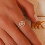 תקריב של יד שעונדת טבעת יהלום ליד תיק אופנה.