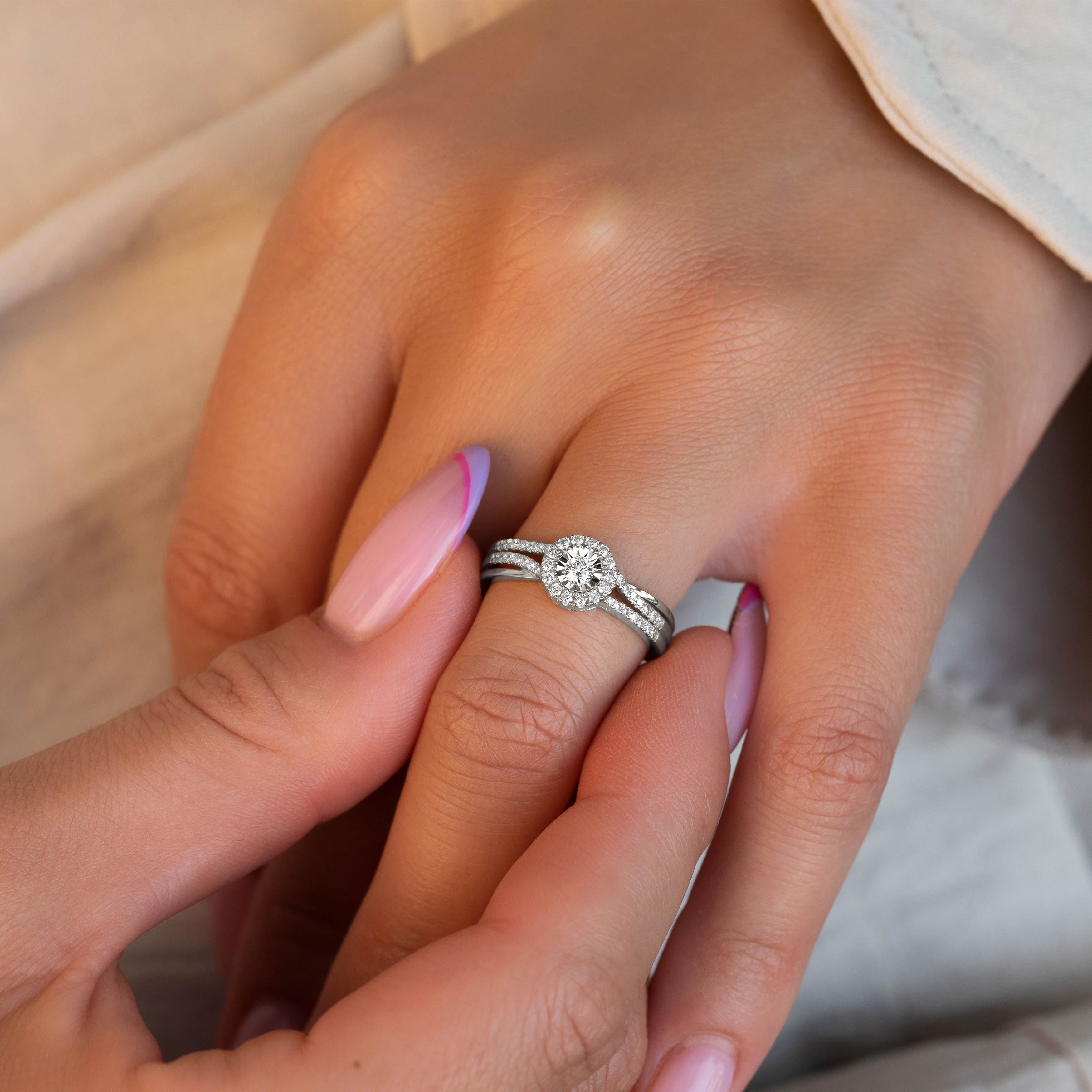 תקריב של יד עונדת טבעת אירוסין עם יהלום ובעלת פס מעוגל.