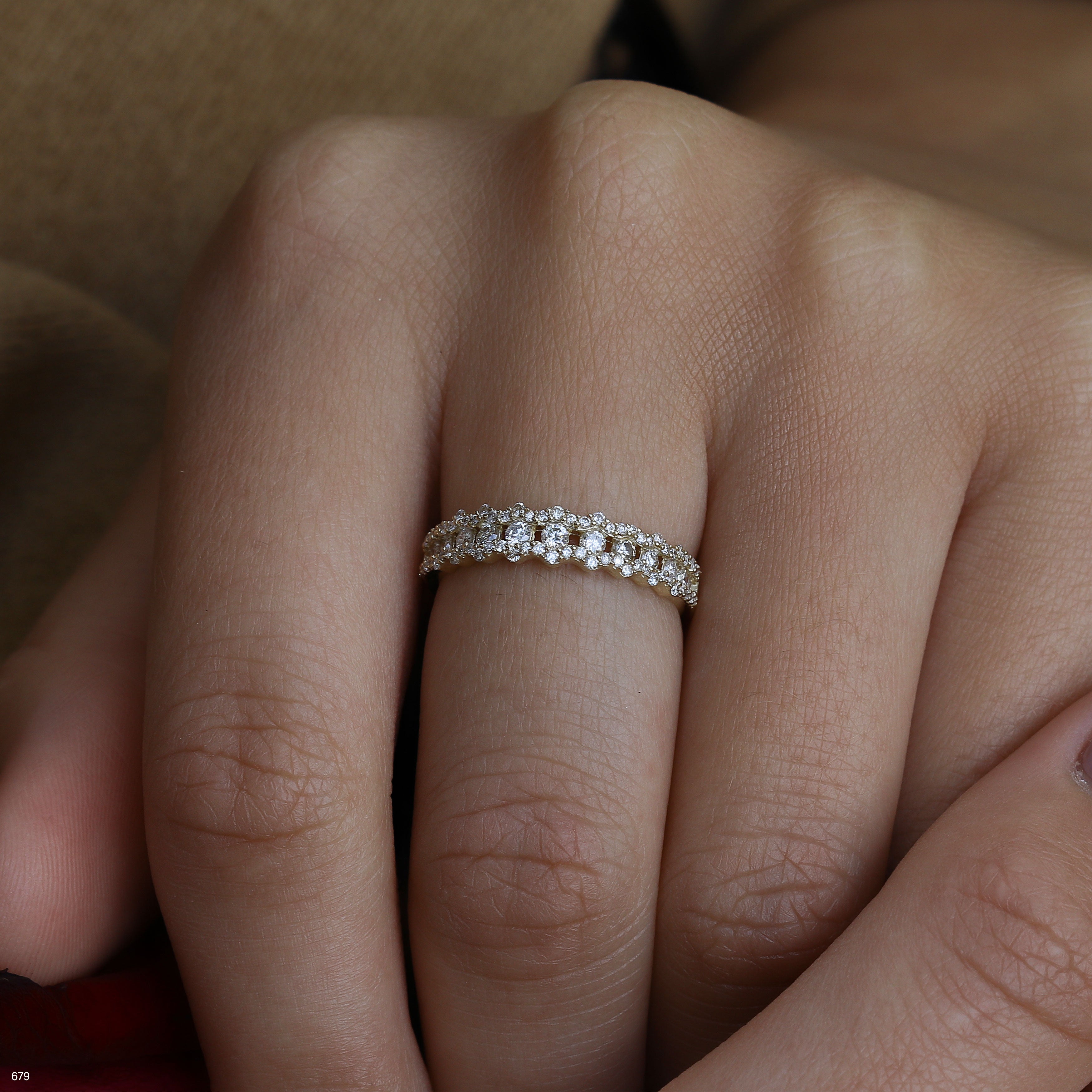 תקריב של יד עם טבעת מעוטרת הכוללת אבנים קטנות.