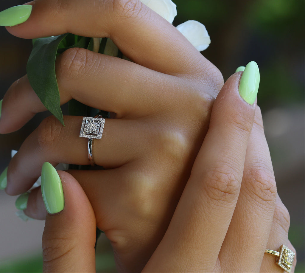 שתי ידיים עם לק אופנתי וטבעות, מחזיקות זר קטן.