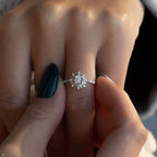 תקריב של יד עם ציפורניים מטופחות המפגינה טבעת אירוסין עם יהלום מבריק.