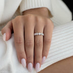 תקריב של יד עם טבעת יהלום וציפורניים מטופחות.