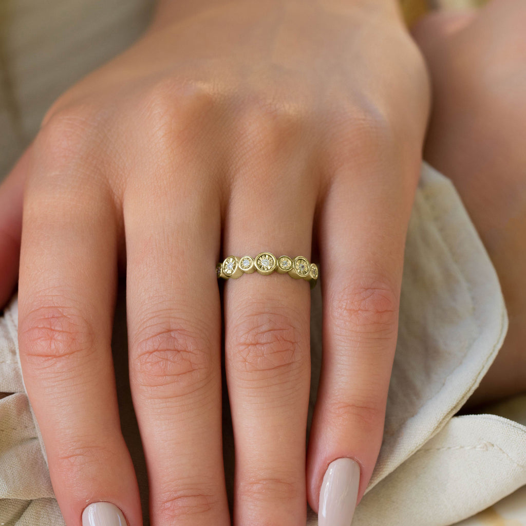 תקריב של יד עונדת טבעת זהב עם אבני חן