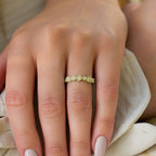 תקריב של יד עונדת טבעת זהב עם אבני חן