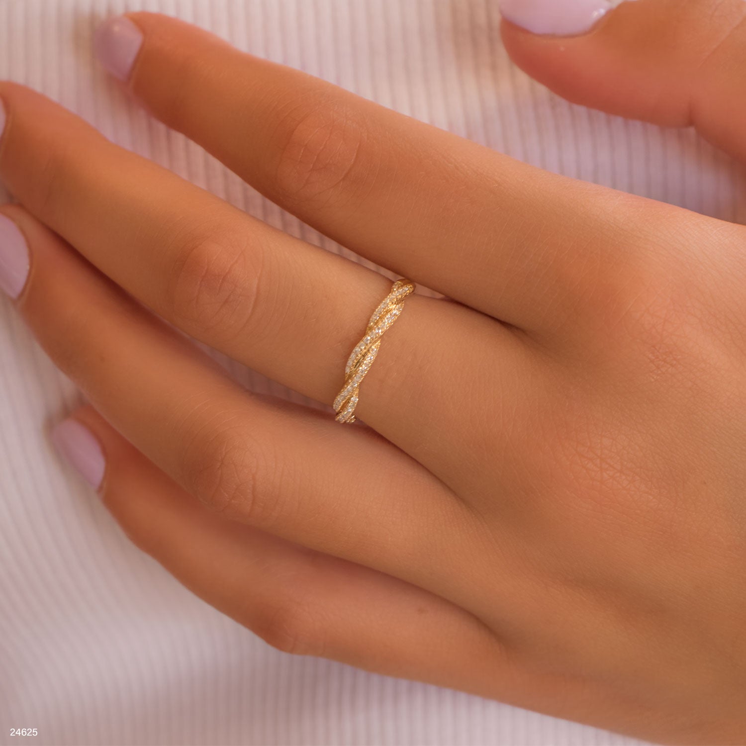 תקריב של יד עונדת טבעת זהב מעוקלת עדינה.