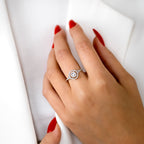 תקריב של יד עונדת טבעת כסף עם עיצוב מעגלי ואבנים מנצנצות.