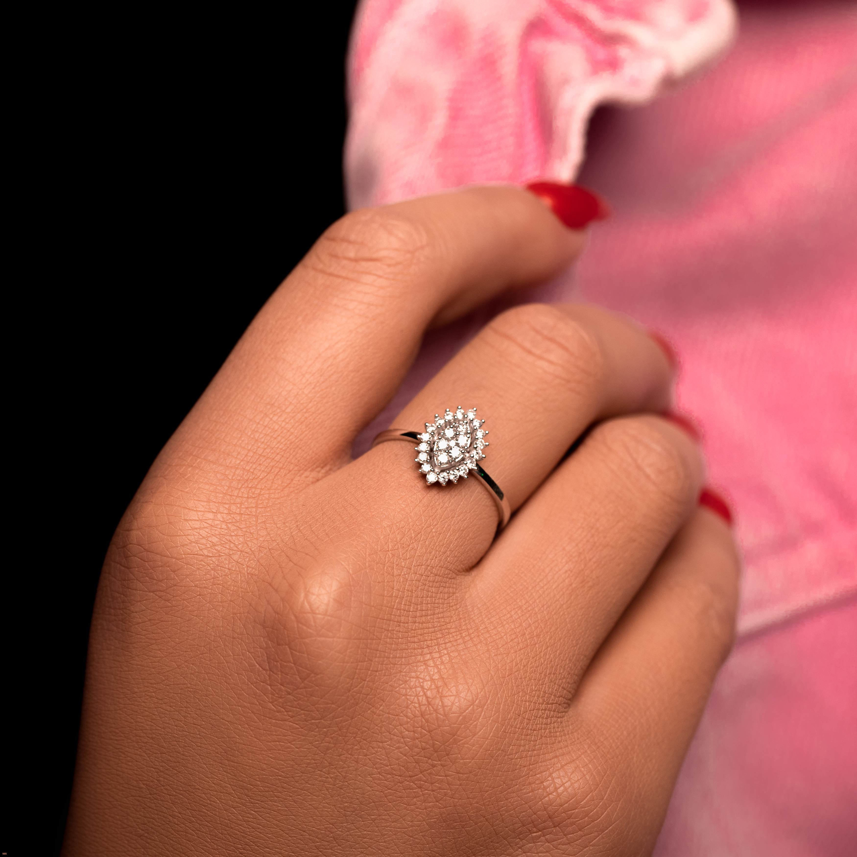 תקריב של יד לובשת טבעת מעוצבת עם עיצוב של פנינה.