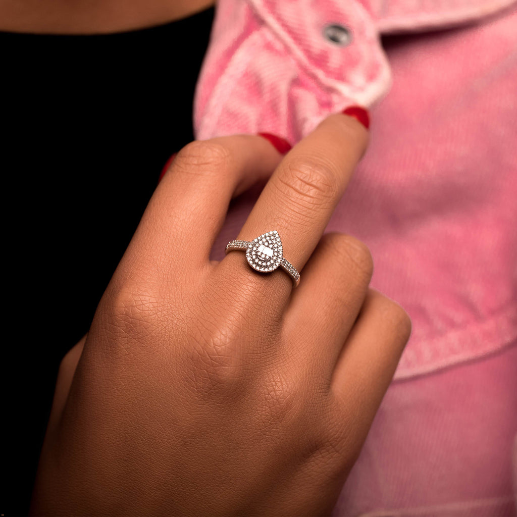 תקריב של יד עונדת טבעת בצורת טיפה מנצנצת.