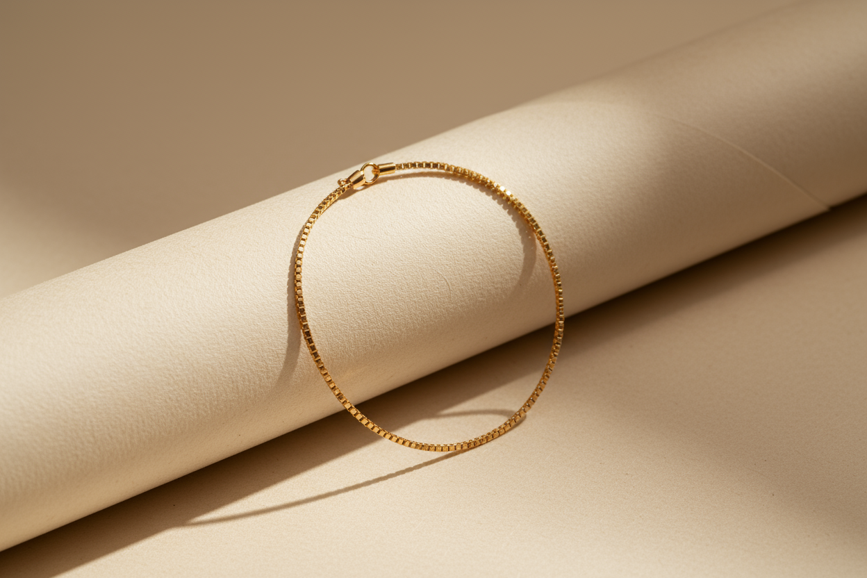 Gold chain bracelet on beige paper