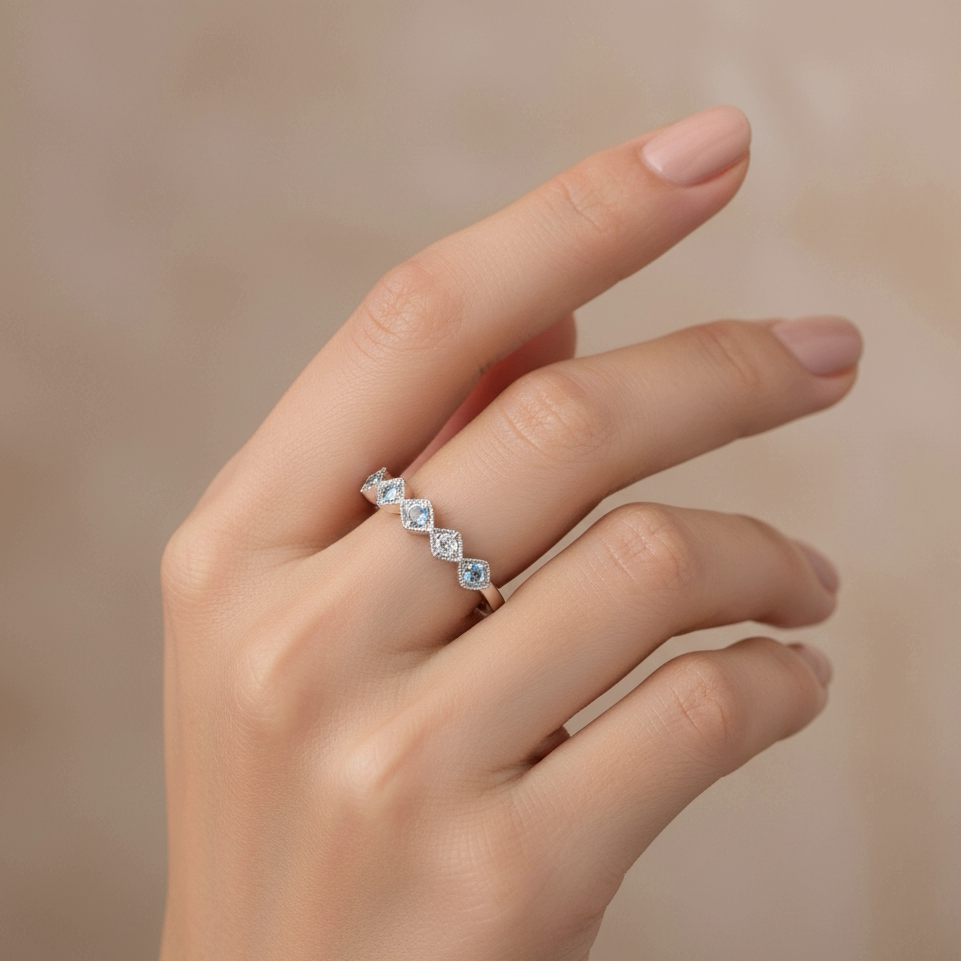 יד מציגה טבעת כסף עם חמישה אבנים מנצנצות.