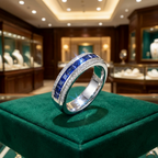 טבעת כסף מדהימה מעוטרת באבני חן כחולות, מוצגת באלגנטיות על משטח קטיפה ירוק בחנות תכשיטים.