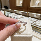 יד מחזיקה בטבעת כסף עם מספר אבני חן, מוצגת בחנות תכשיטים.